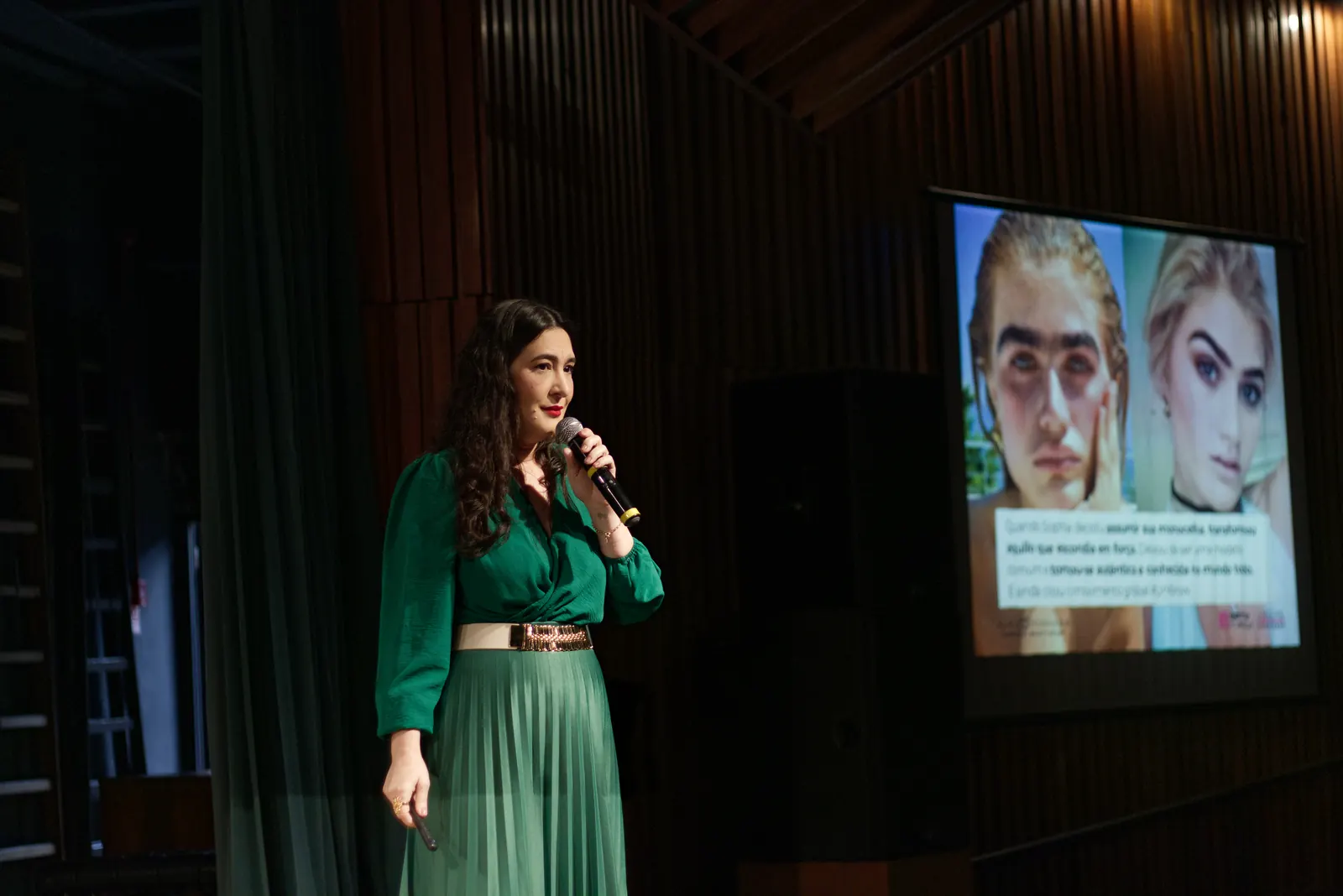 Palestrante no palco com projeção ao fundo
